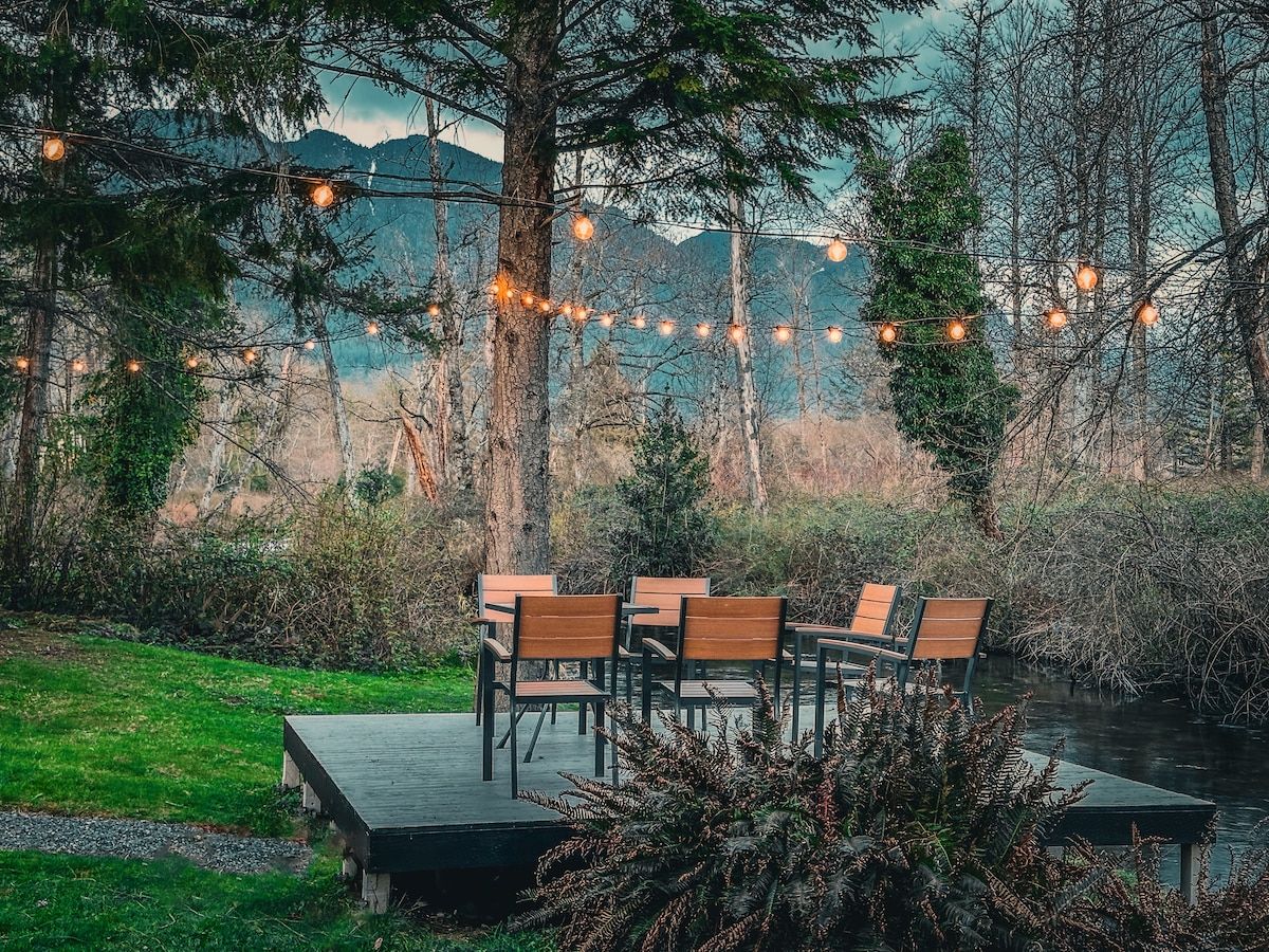 Creekside deck with seating, string lights and mountain views